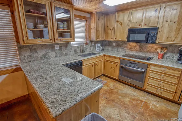 a kitchen with stainless steel appliances granite countertop wooden cabinets and a counter top