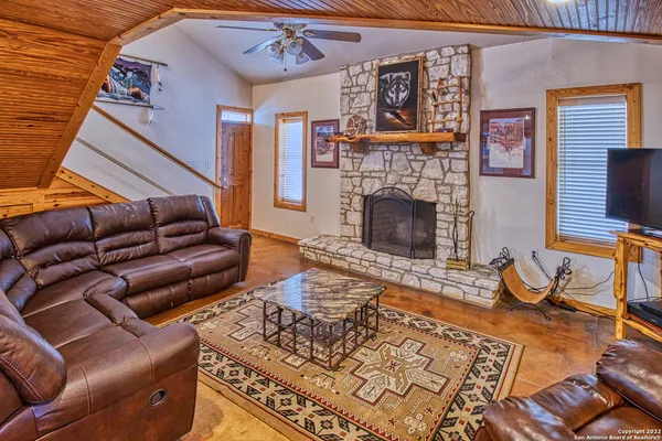 a living room with furniture a flat screen tv and a fireplace