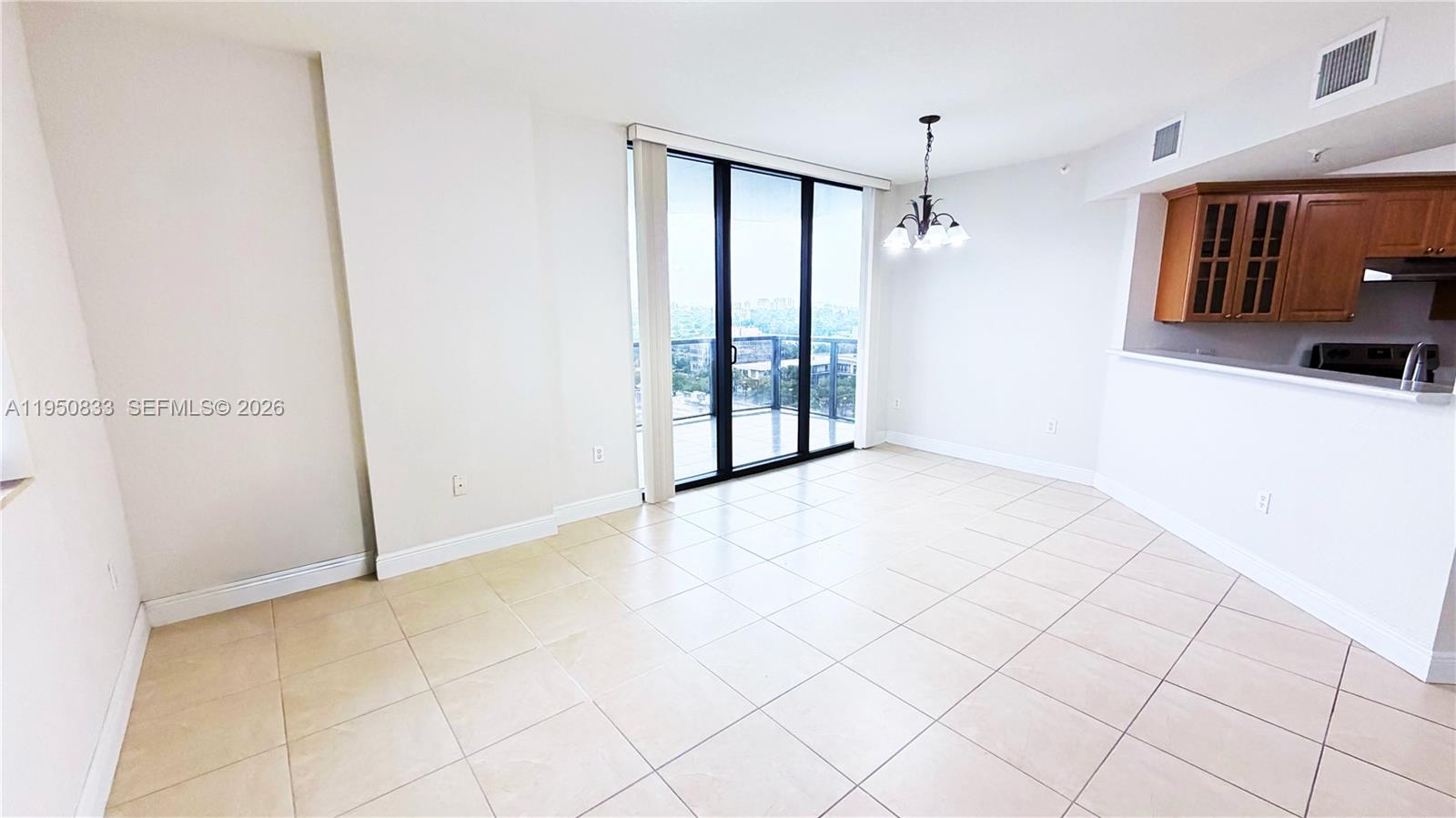 2301 Southwest 27th Avenue, Unit 1200 Miami, FL 33145 - Photo 12 of 24 a view of an empty room with window and chandelier