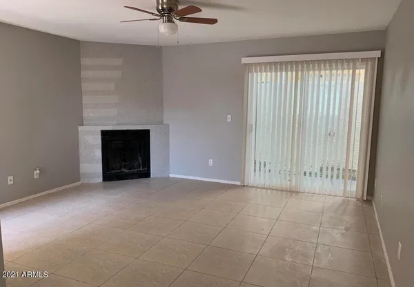 an empty room with windows and fireplace
