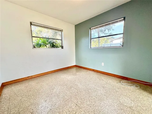 a spacious bedroom with a bed window and couch