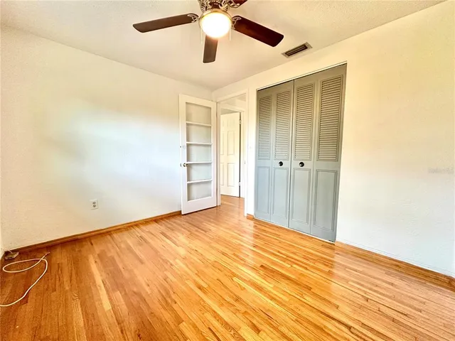 a bedroom with bed and ceiling fan