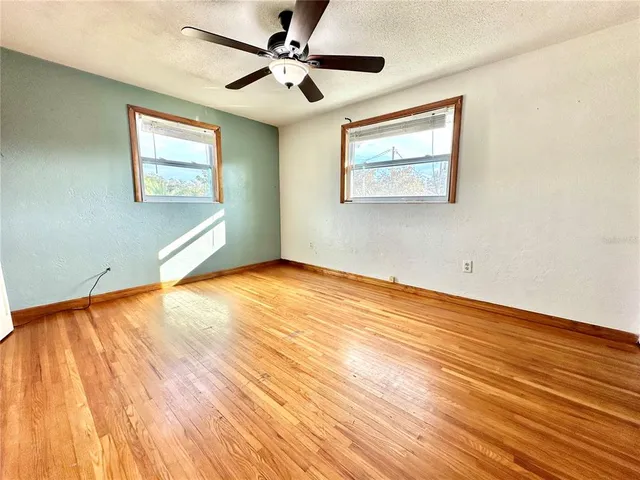 a view of an empty room with wooden floor
