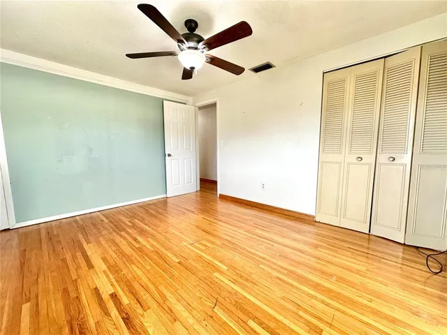 a view of an empty room with wooden floor