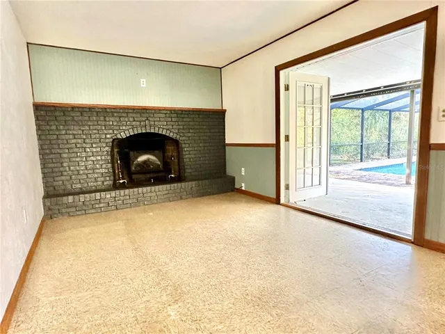 a view of an empty room with a fireplace and a window