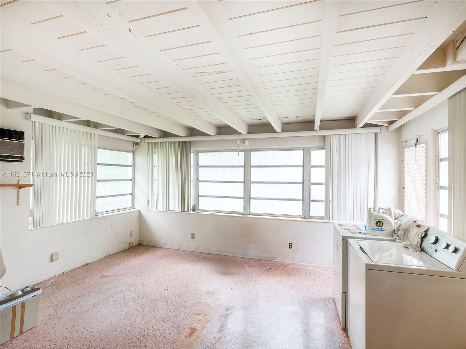 820 Southwest 26th Road Miami, FL 33129 - Photo 6 of 20 a big room with windows and chandelier fan