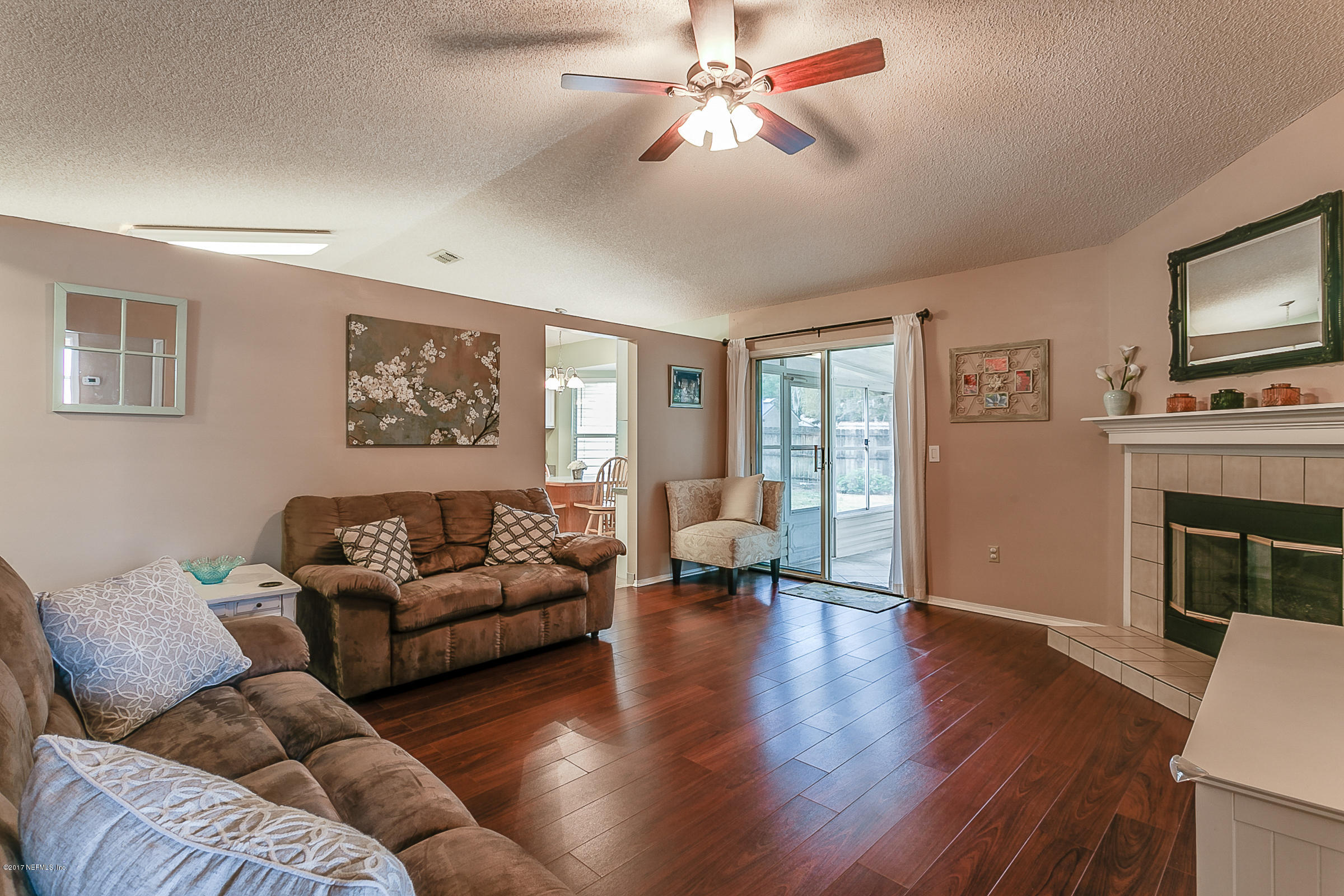 1270 Cutlass Road Orange Park, FL 32065 - Photo 14 of 28 a living room with furniture a flat screen tv and a fireplace