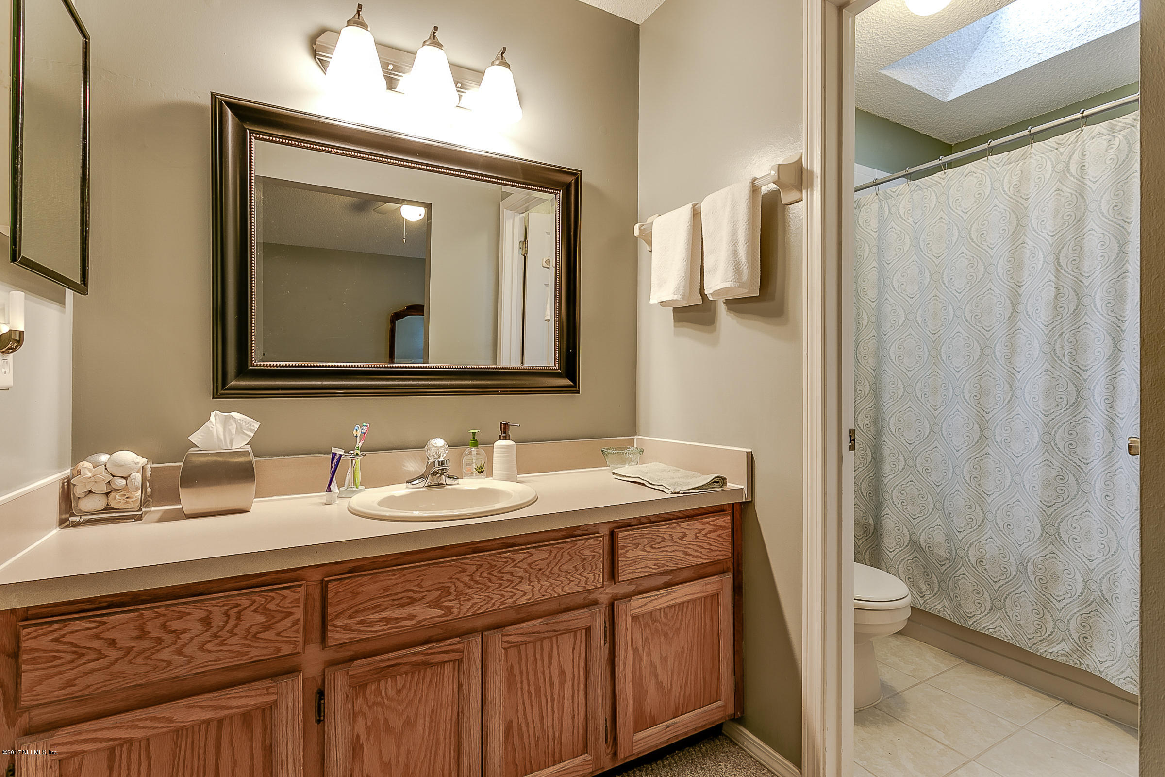 1270 Cutlass Road Orange Park, FL 32065 - Photo 18 of 28 a bathroom with a double vanity sink and mirror with shower