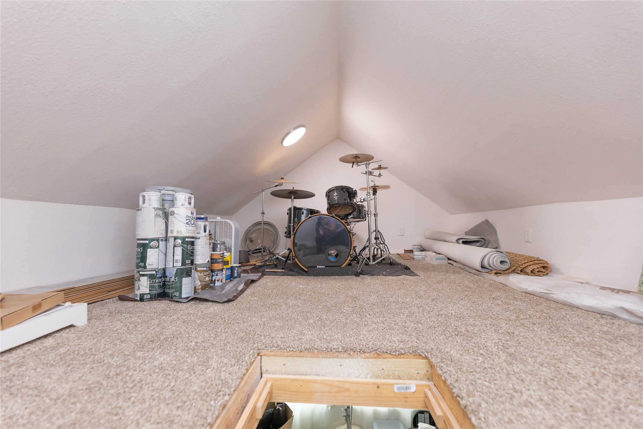 8007 Capitol Street Houston, TX 77012 - Photo 24 of 25 This space is a finished attic with carpeted flooring, ideal for storage or a hobby area. It features a small round window for natural light.