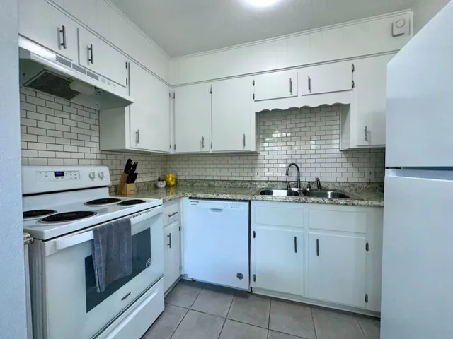 a kitchen with cabinets appliances a sink and a counter top