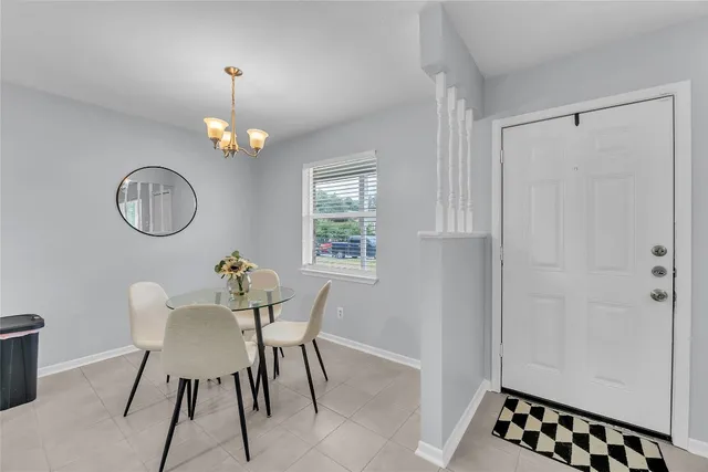 a view of a dining room with furniture a chandelier and wooden floor