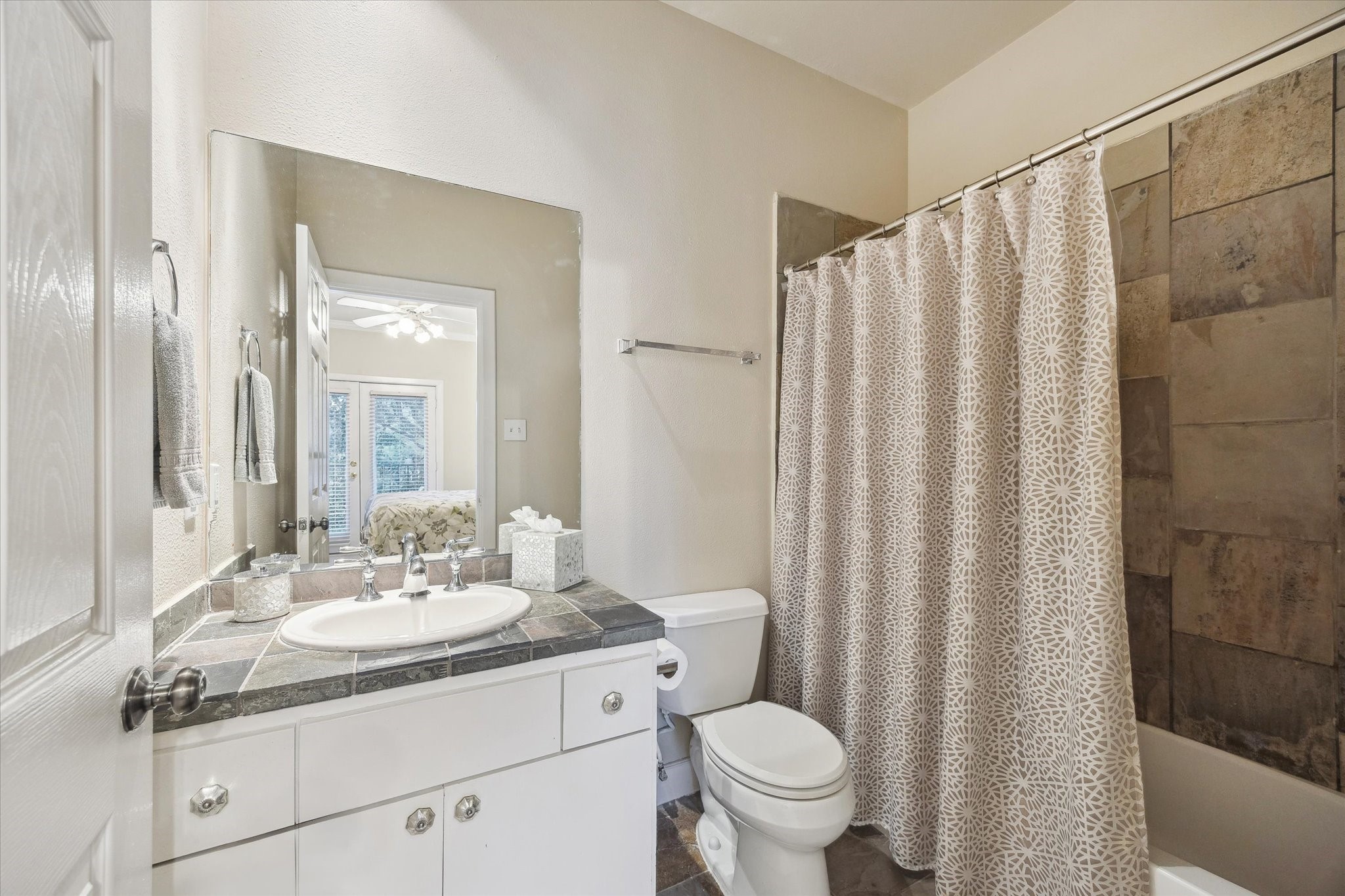 1342 Rutland Street, Unit 203 Houston, TX 77008 - Photo 14 of 20 a bathroom with a granite countertop sink toilet and a mirror