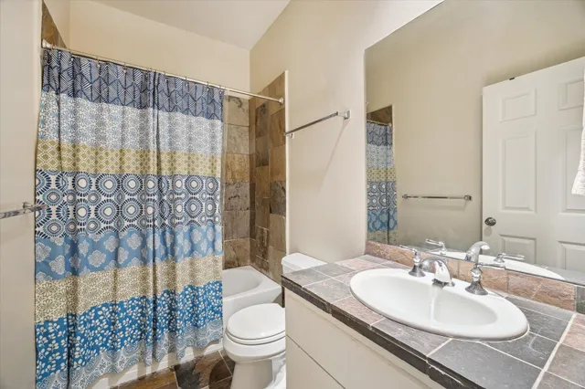 a bathroom with a sink toilet and shower