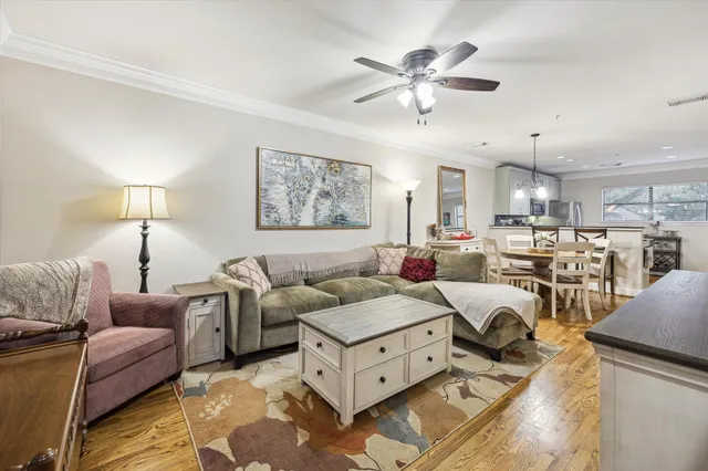 a living room with furniture kitchen view and a chandelier