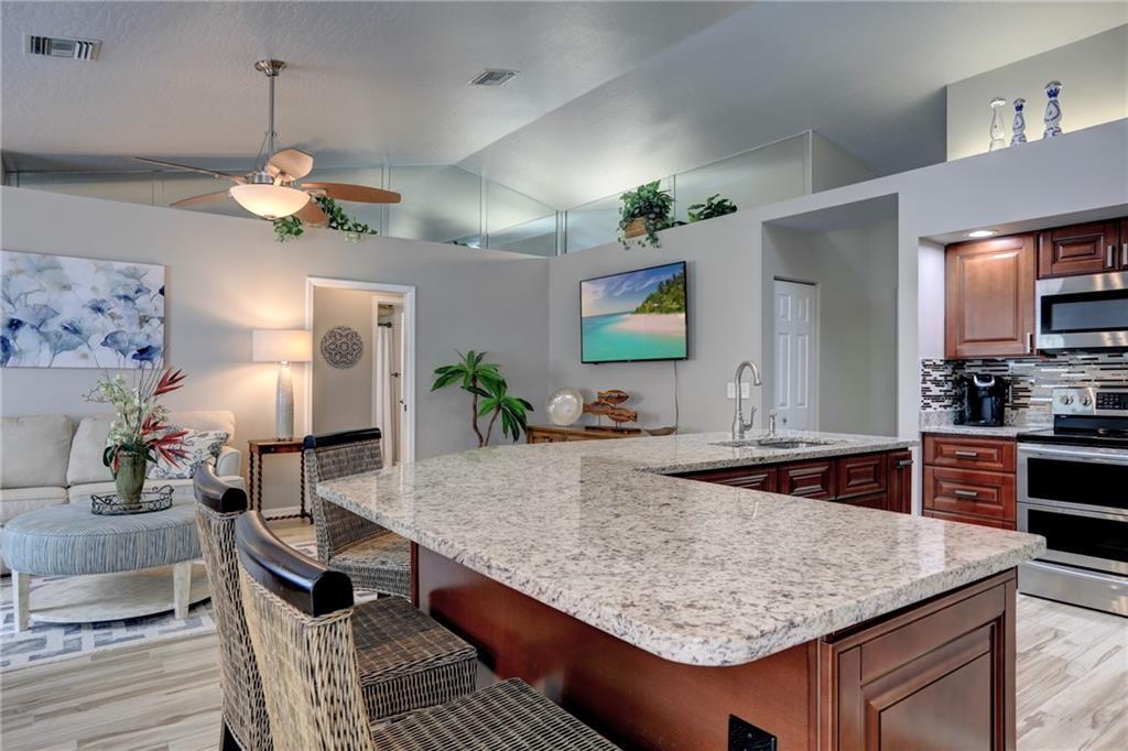 562 Rolling Hill Drive Sebastian, FL 32958 - Photo 12 of 42 a kitchen with kitchen island granite countertop a sink stove and refrigerator