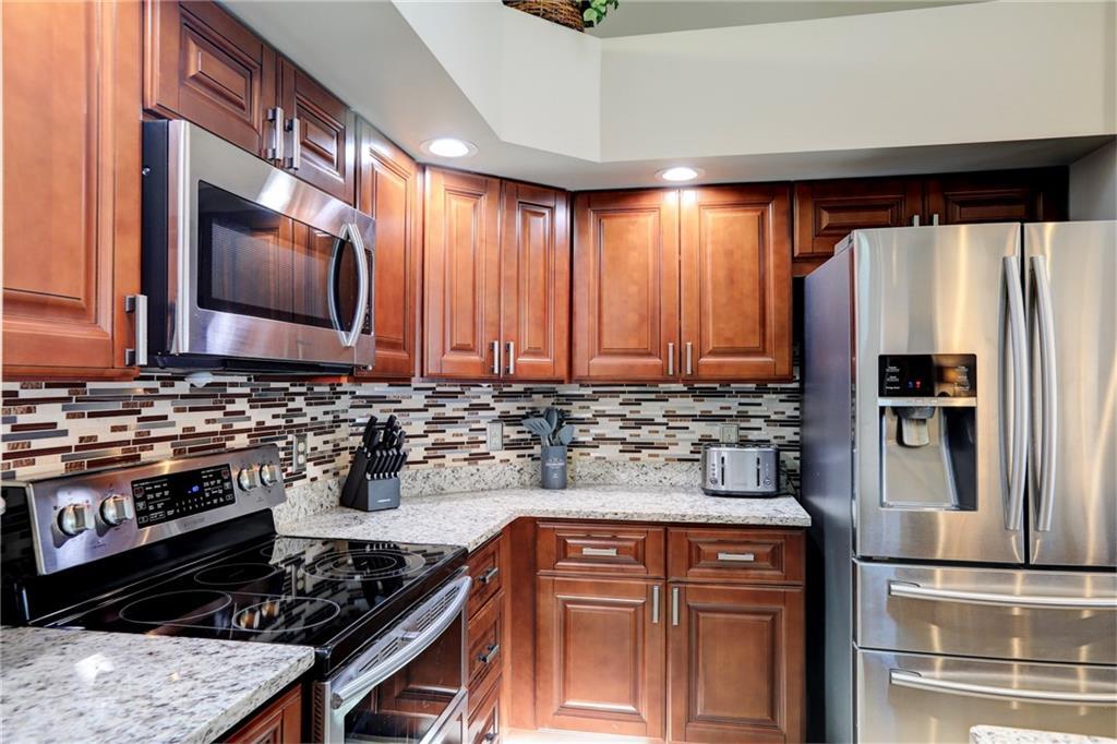 562 Rolling Hill Drive Sebastian, FL 32958 - Photo 16 of 42 a kitchen with stainless steel appliances granite countertop a stove a sink and a refrigerator