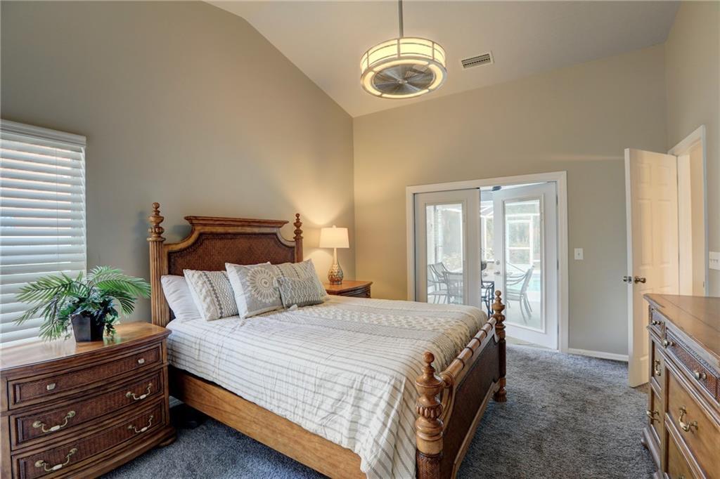 562 Rolling Hill Drive Sebastian, FL 32958 - Photo 19 of 42 a spacious bedroom with a bed and a chandelier