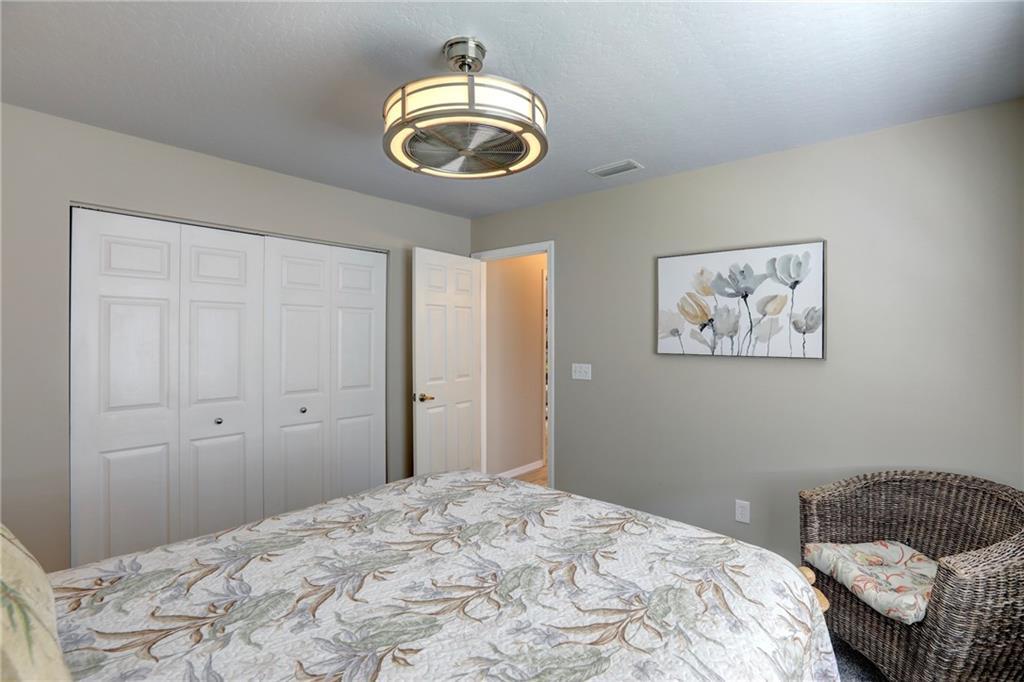 562 Rolling Hill Drive Sebastian, FL 32958 - Photo 26 of 42 a bedroom with a bed and a chandelier