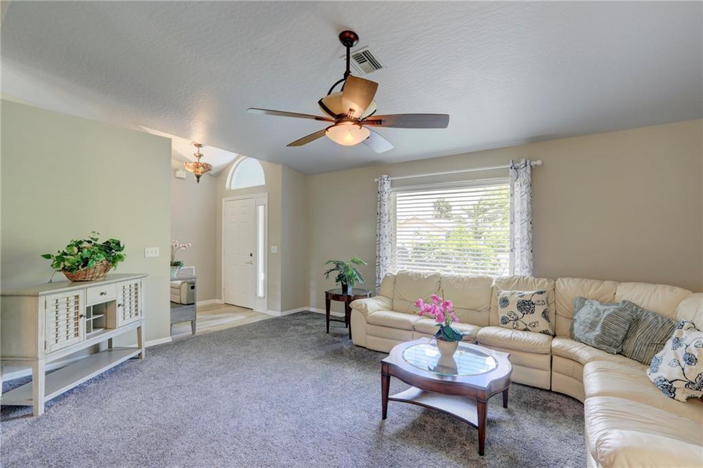 562 Rolling Hill Drive Sebastian, FL 32958 - Photo 7 of 42 a living room with furniture a chandelier and a window
