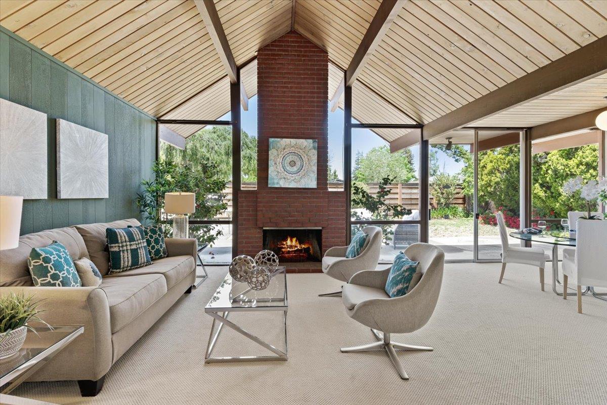 a living room with furniture a fireplace and a large window