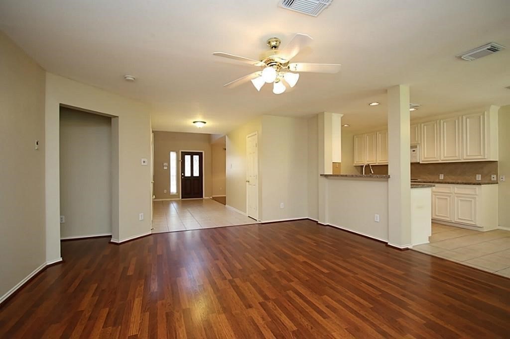 28511 Cory Terrace Court Spring, TX 77386 - Photo 12 of 31 a view of an empty room with wooden floor and a kitchen