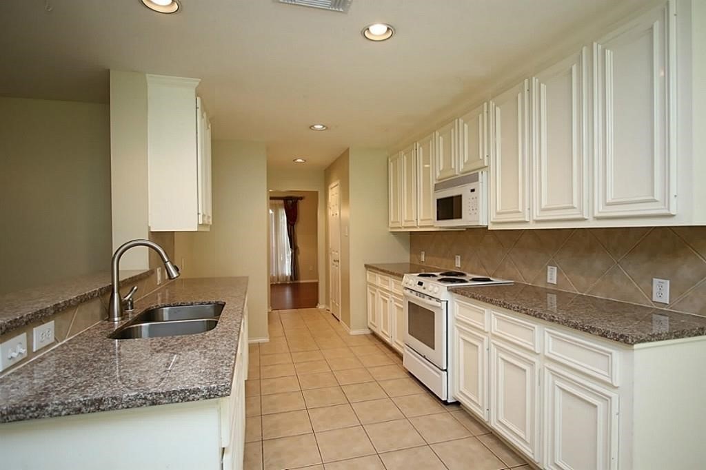 28511 Cory Terrace Court Spring, TX 77386 - Photo 14 of 31 a kitchen with stainless steel appliances granite countertop a sink stove and cabinets