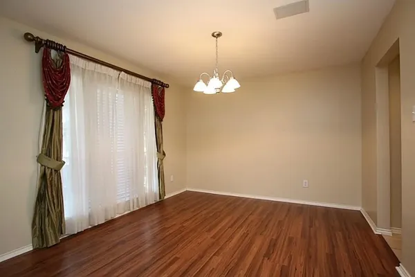 a view of a livingroom with wooden floor and a ceiling fan