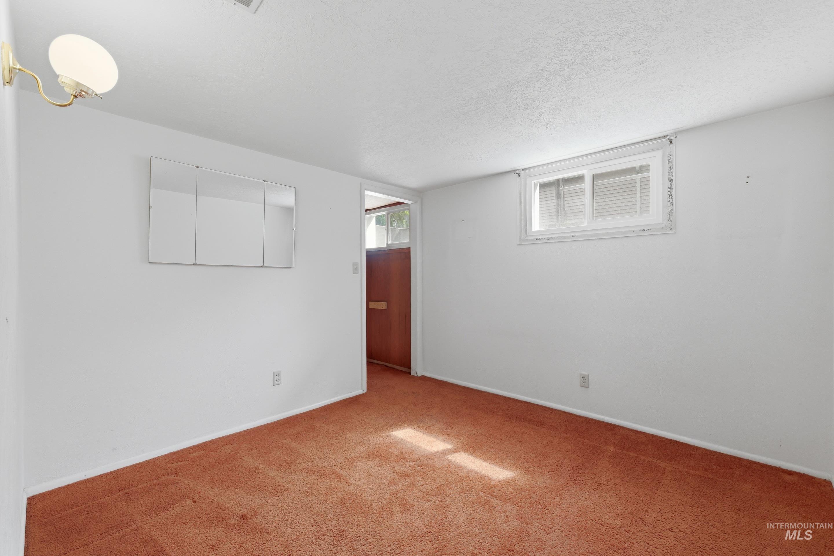 504 West Howe Street Boise, ID 83706 - Photo 29 of 47 Carpeted room featuring white walls, a single window with blinds, and a built-in wall sconce