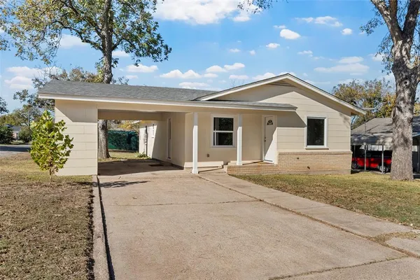 a view of a house with a patio and a yard