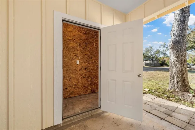 a view of a porch with a door and wooden floor