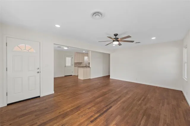 a view of a livingroom with wooden floor and a ceiling fan