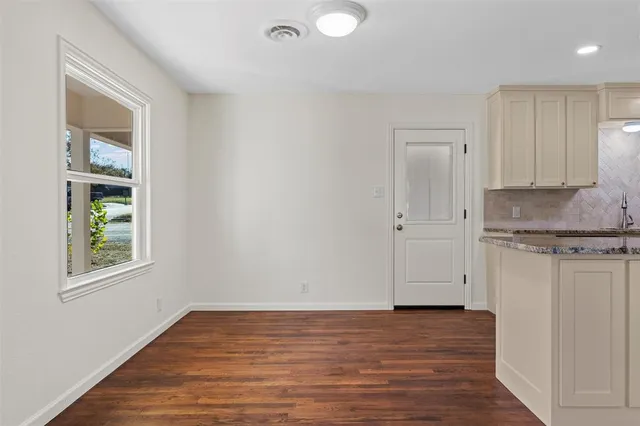 a view of a kitchen with granite countertop cabinets and wooden floor