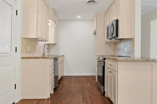 a kitchen with a refrigerator sink and cabinets