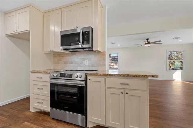 a kitchen with granite countertop a stove and a microwave