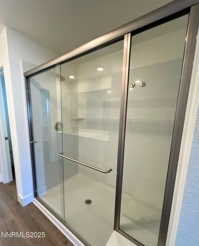 a bathroom with a glass shower door and a mirror