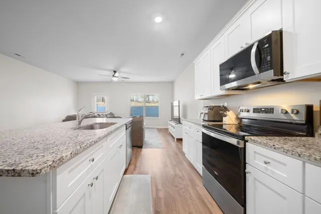 a large kitchen with stainless steel appliances granite countertop a sink and stove top oven