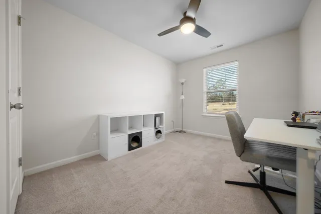 a view of a workspace with furniture and a window