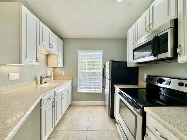a kitchen with stainless steel appliances granite countertop a sink and a stove