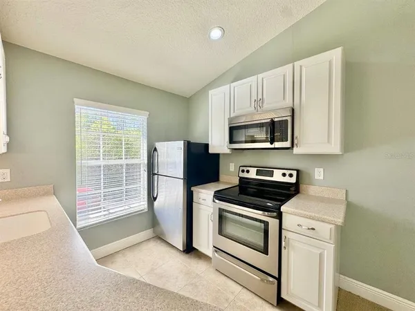 a kitchen with a stove a microwave and a refrigerator
