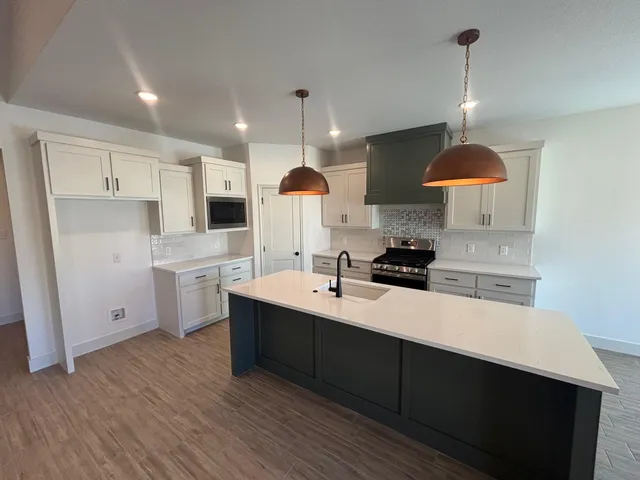 a kitchen with kitchen island a sink stainless steel appliances and cabinets