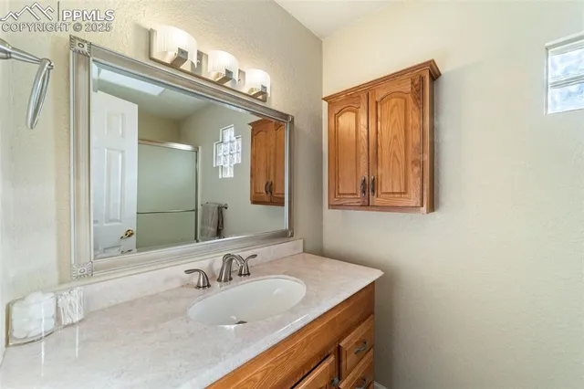 a bathroom with a granite countertop sink and a mirror