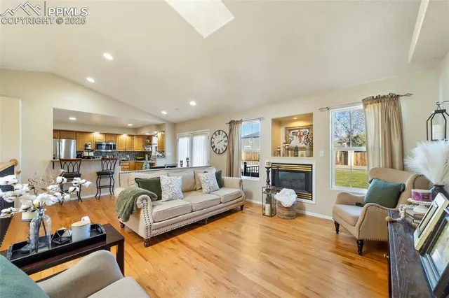a living room with fireplace furniture and a large window