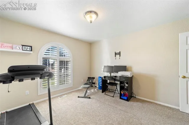 a view of a workspace with furniture and a window