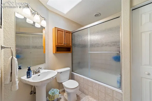 a bathroom with a sink toilet a mirror and shower