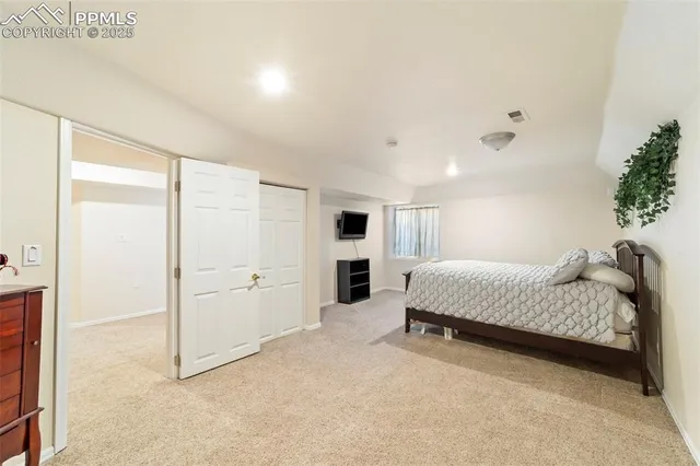 a spacious bedroom with a bed and a cabinets