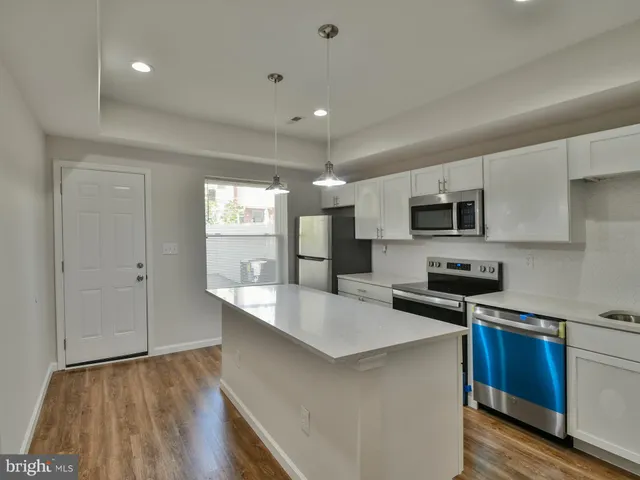 a kitchen with a sink a microwave a refrigerator and cabinets