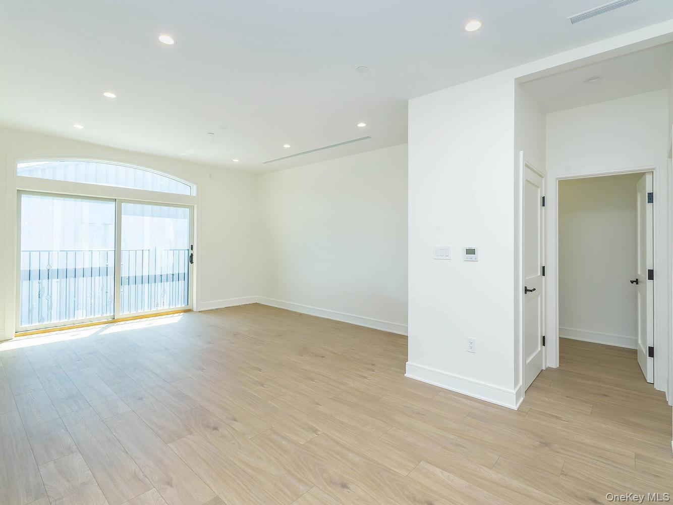 24 Lumber Road, Unit 2 Roslyn, NY 11576 - Photo 12 of 25 an empty room with wooden floor and windows