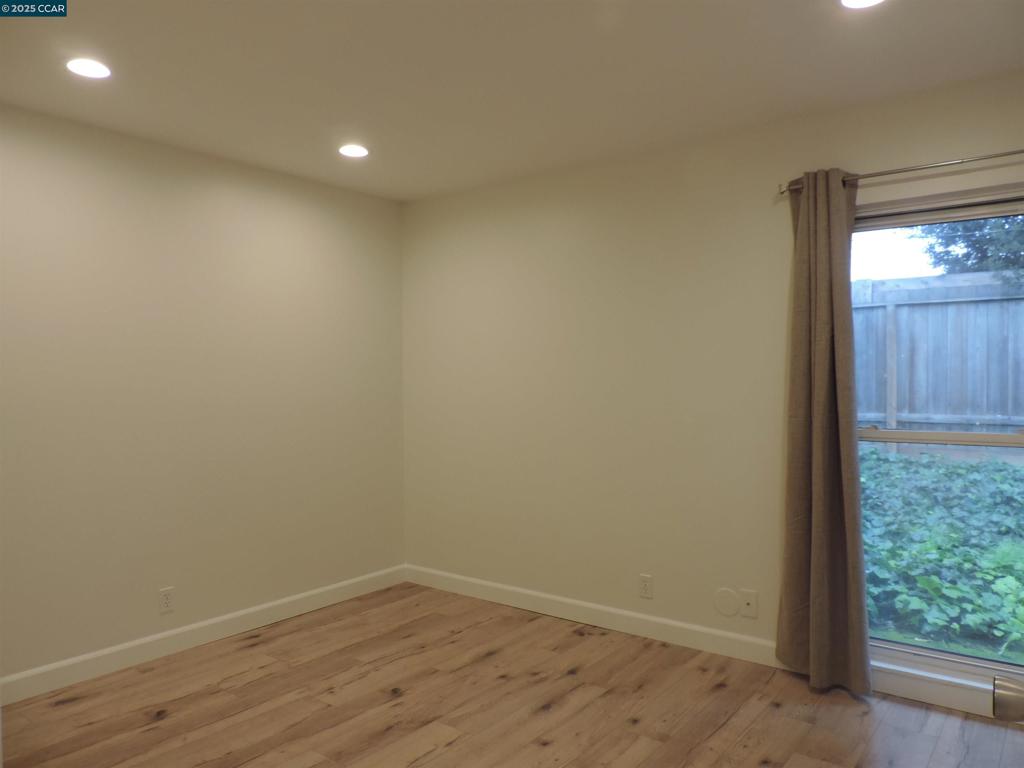 1919 Ygnacio Valley Road Walnut Creek, CA 94598 - Photo 8 of 35 an empty room with wooden floor and windows