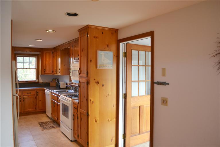 460 Summit Avenue Eastham, MA 02642 - Photo 10 of 25 a kitchen with a refrigerator a sink and wooden cabinets