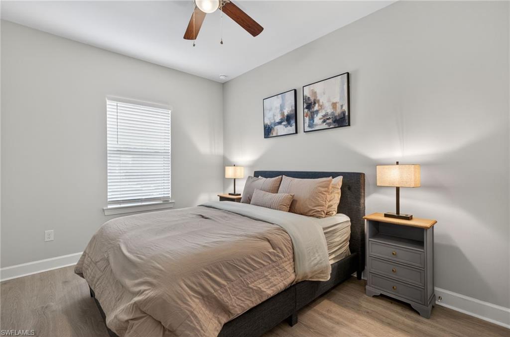 15641 Gavello Street Naples, FL 34114 - Photo 25 of 37 a bedroom with a large bed and a chandelier
